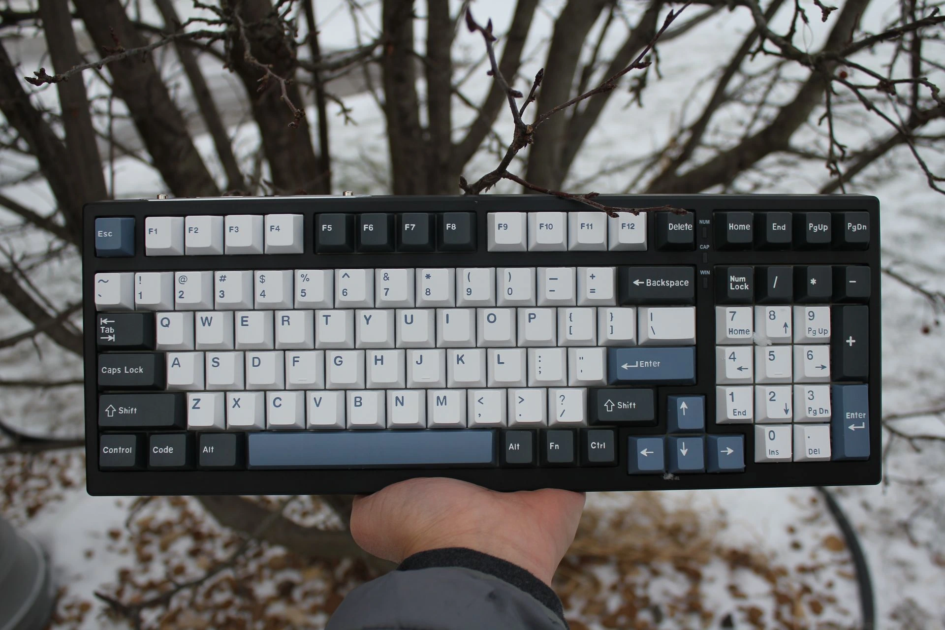 Custom mechanical keyboard photographed outdoors by Must Keebs